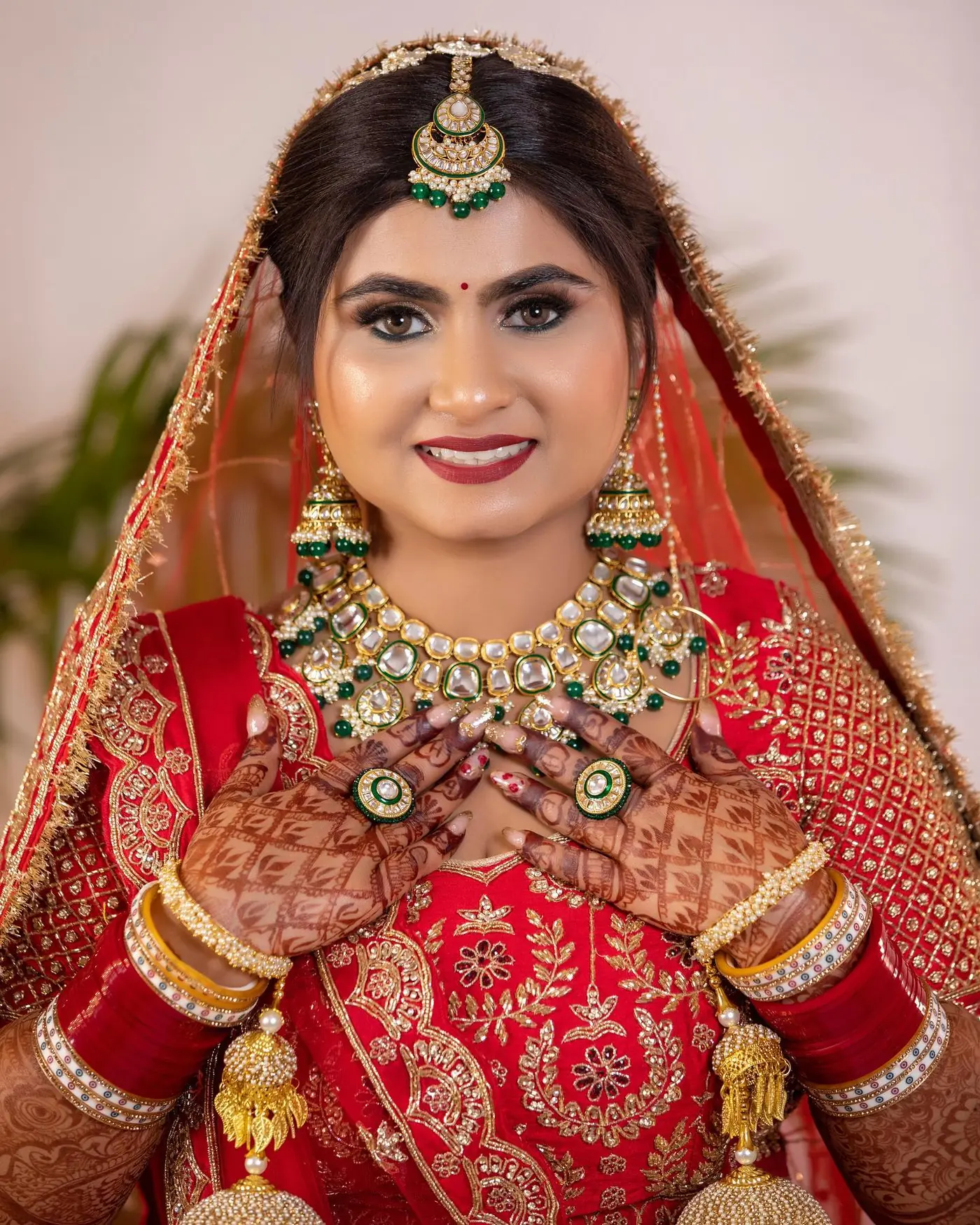 Red Veil, Hands Folded in Greeting. Bridal makeup by Madhu Gupta at MG Makeovers, Gurugram
